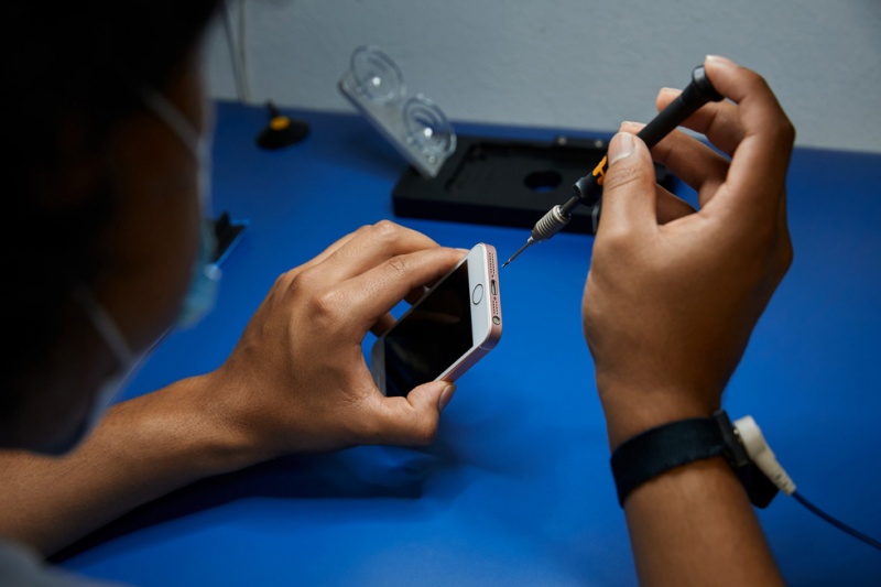 A technician repairing an iPhone.